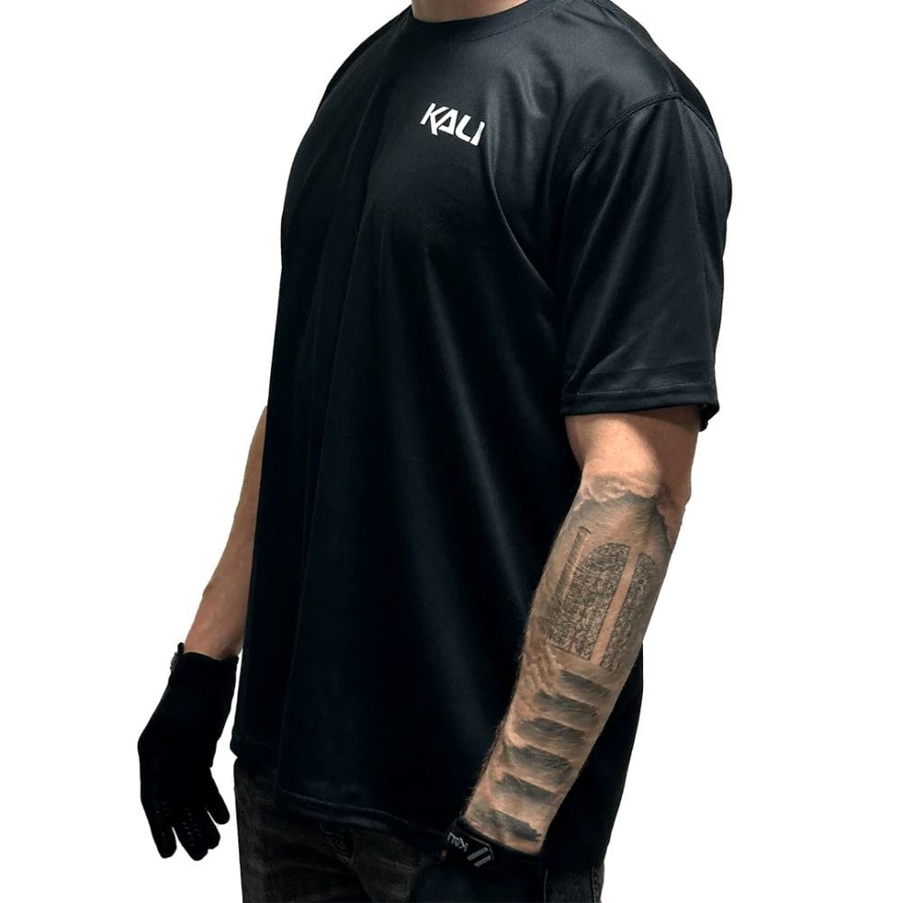Person wearing a black Kali shirt on a white background