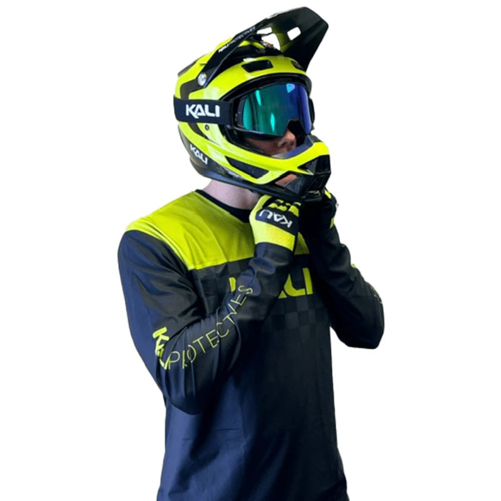 Person wearing a Kali helmet and matching gloves on a white background