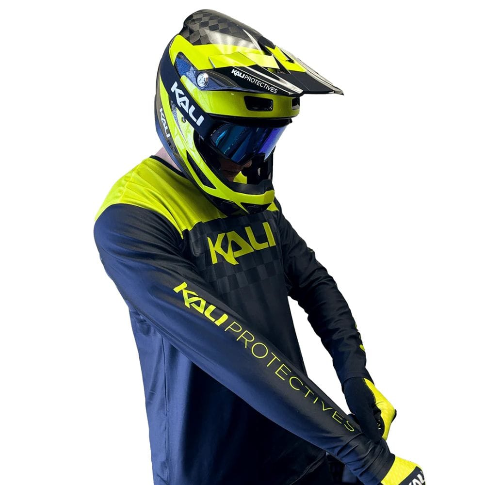 Person wearing a blue and yellow Kali protective gear set on a white background