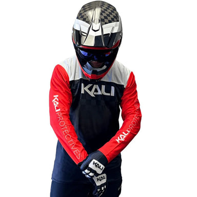 Person wearing a Kali protective gear set with a helmet on a white background
